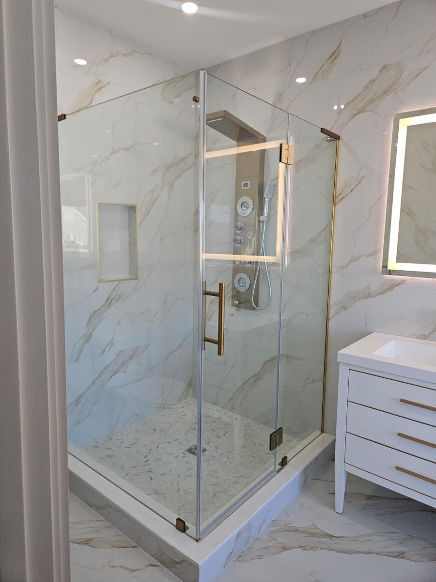 Calacatta marble bathroom with gold fixtures and glass shower