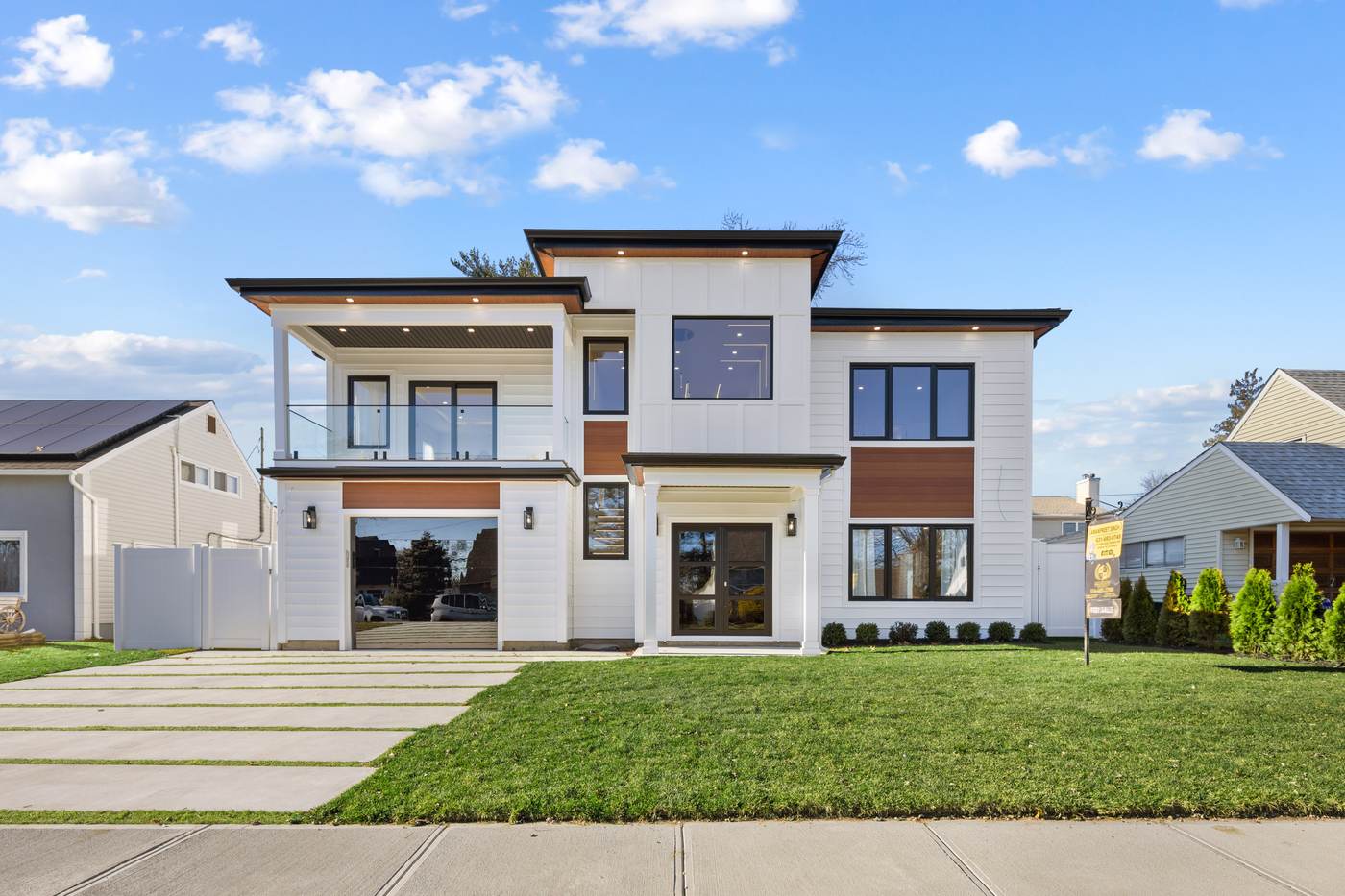 Modern white board and batten new construction home with cedar accents